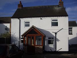 Rear view of the cottage and parking area