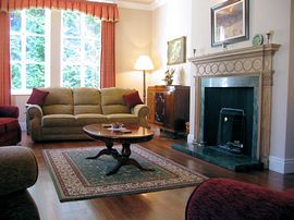 Drawing room with a Victorian fireplace and period chandelier.