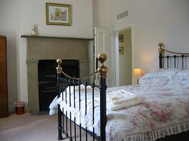 Double room, with brass bedstead, was originally a kitchen for the ostler and still contains the original Victorian kitchen range.
