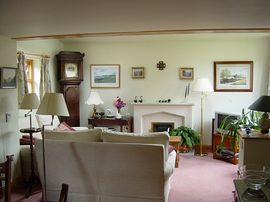 Spacious lounge/dining room with limestone fireplace and open gas fire.