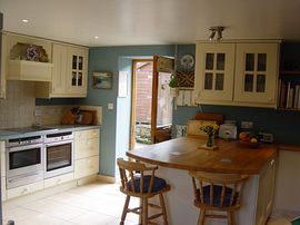 Large, well equipped kitchen with tiled floor and a wide solid beech peninsula unit which is ideal for breakfasting.